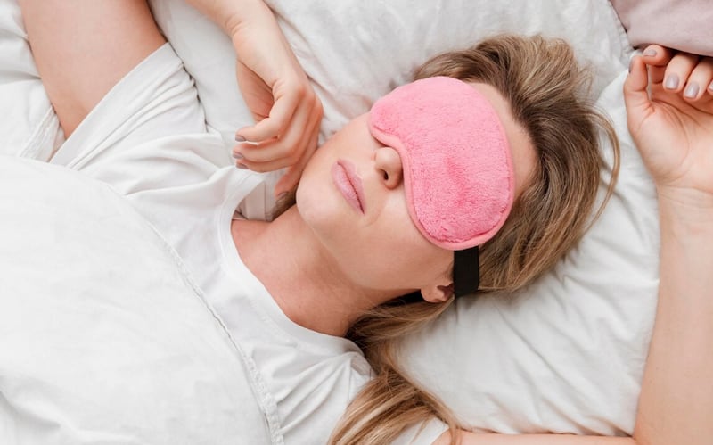 Mujer que llevaba una máscara para dormir en la vista superior de sus ojos